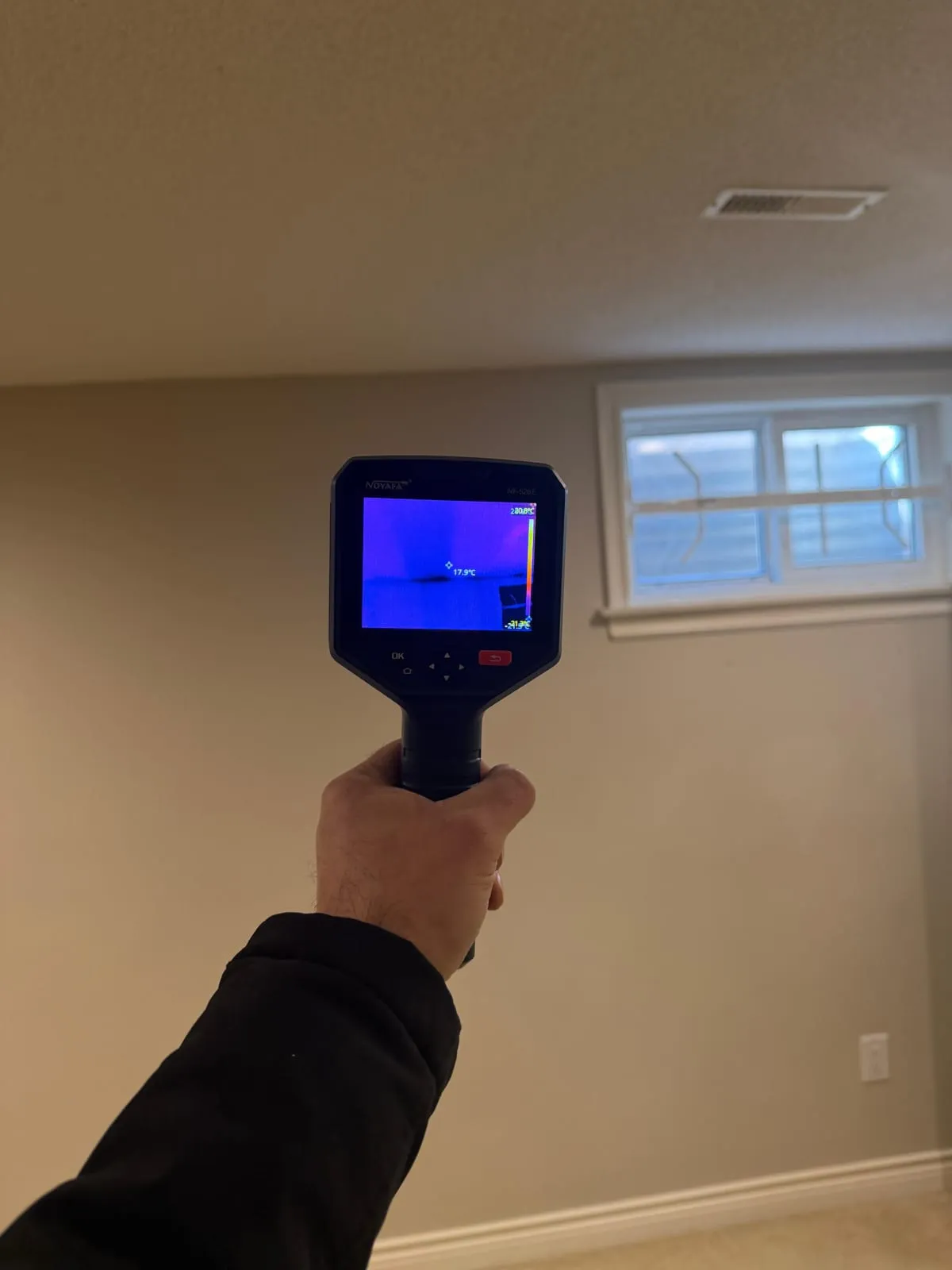 Thermal camera checking a basement wall for moisture during water damage restoration